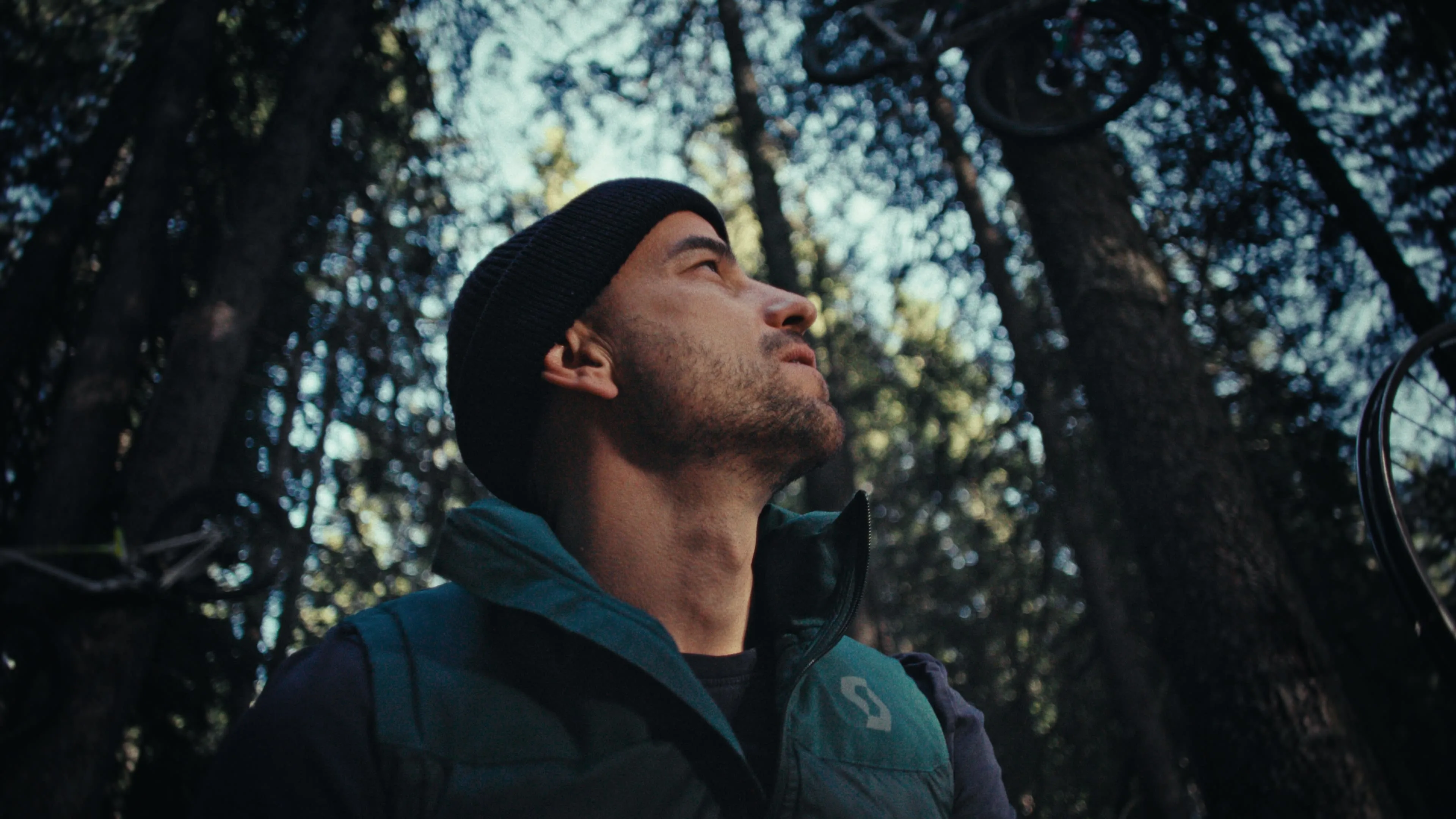 Nino Schurter steht in einem Wald. 