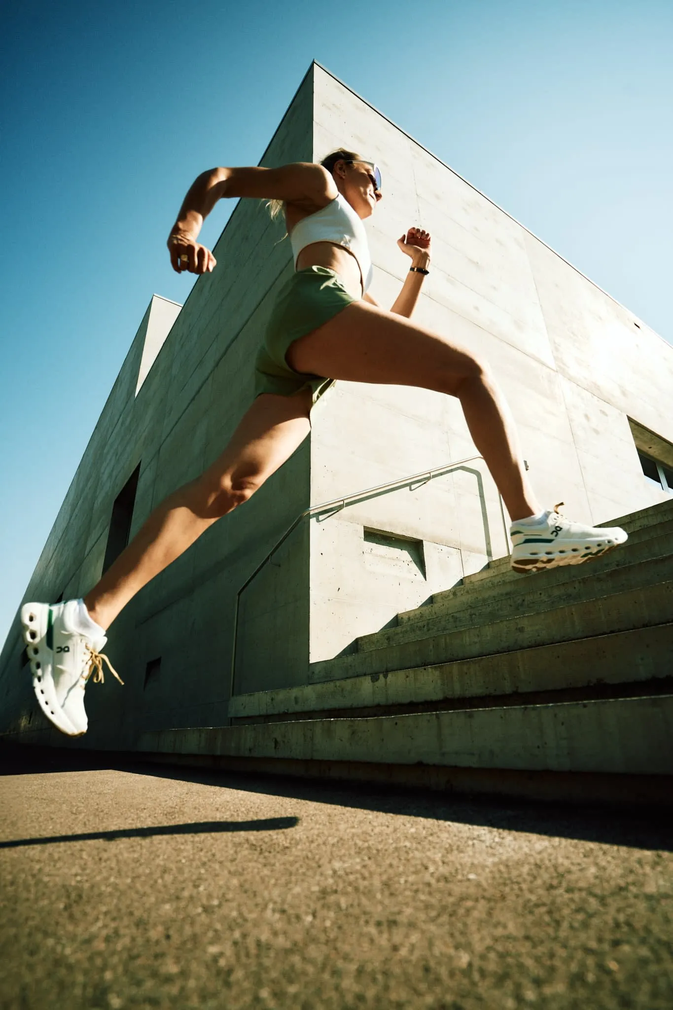 male model wearing ON running shoes styled with modern streetwear, running through an urban backdrop.