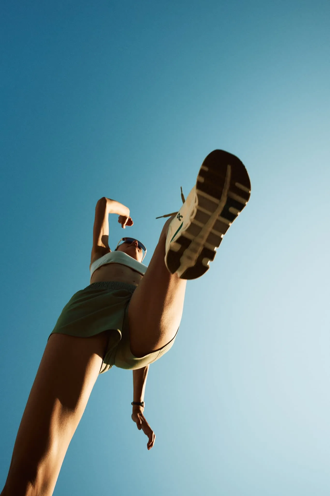 Lifestyle photo of a woman wearing ON running shoes, styled with casual elegance for a fashion-forward look.