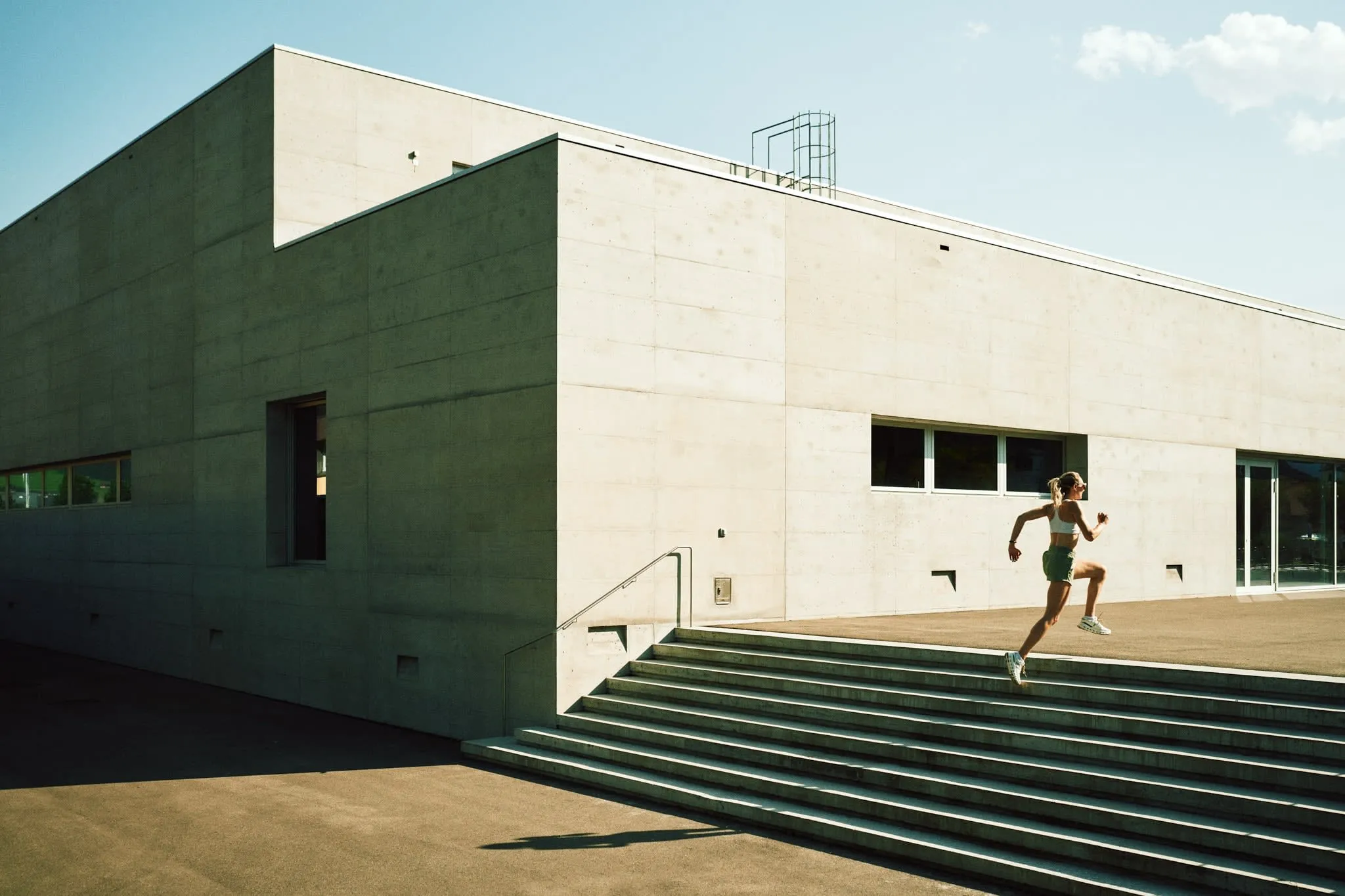 Woman in contemporary outfit featuring ON sneakers, captured in soft natural light for a lifestyle shoot.