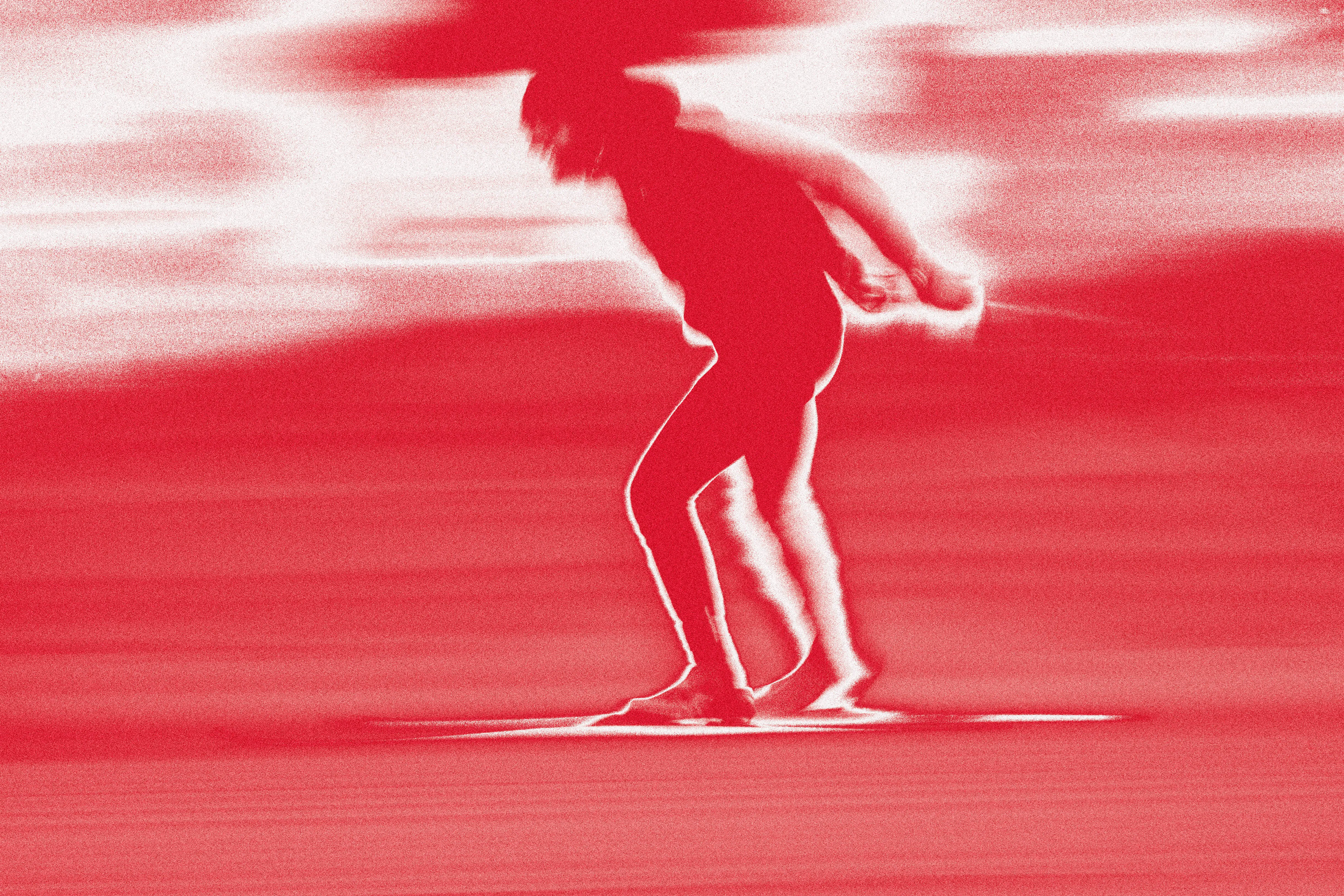 A highly stylized, abstract action shot of a cross-country skier in motion, rendered in a high-contrast red and white "heat map" or infrared-style effect. The image emphasizes the speed and dynamic posture of the athlete during a glide.